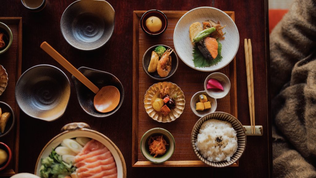 Comida tradicional japonesa servida en un conjunto de platos pequeños.