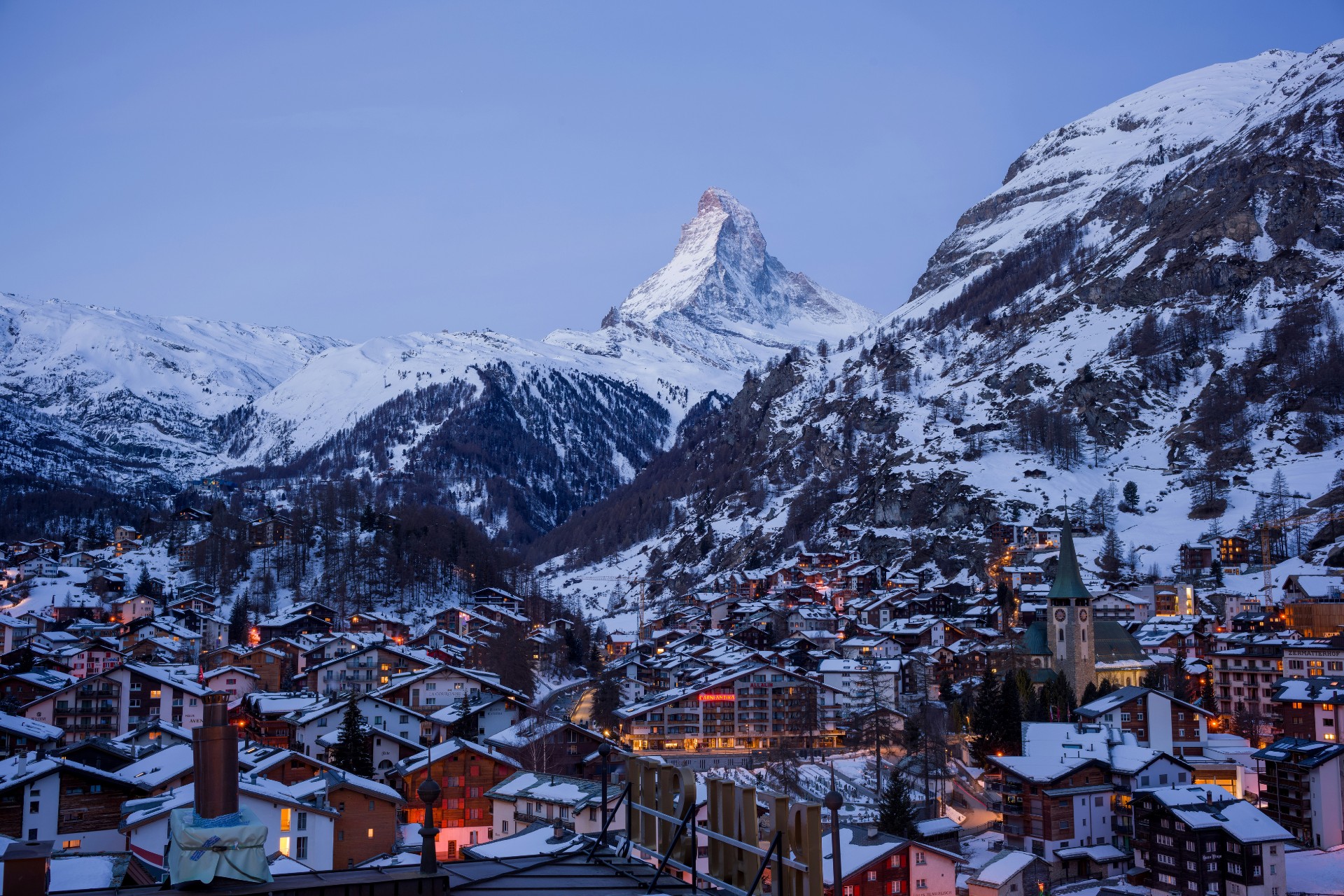 Vista de Zermatt, Suiza, con el Matterhorn nevado y una aldea alpina.