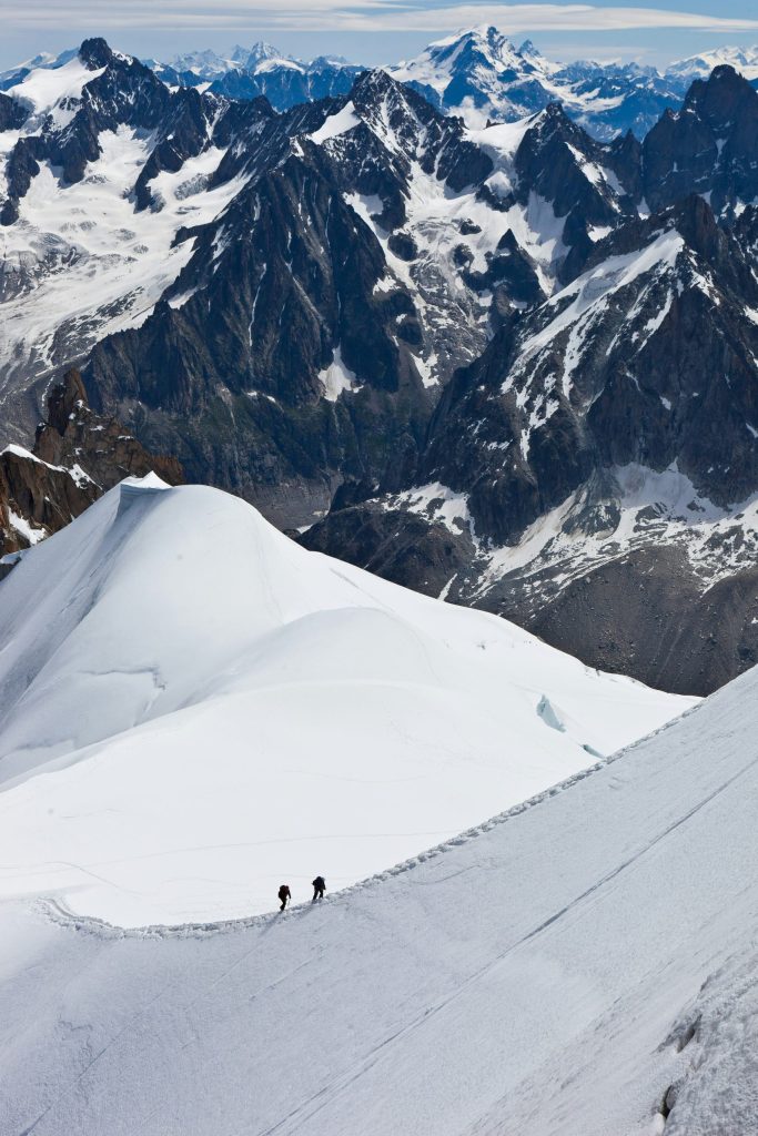 Montañistas escalando una cumbre nevada en los Alpes suizos.
