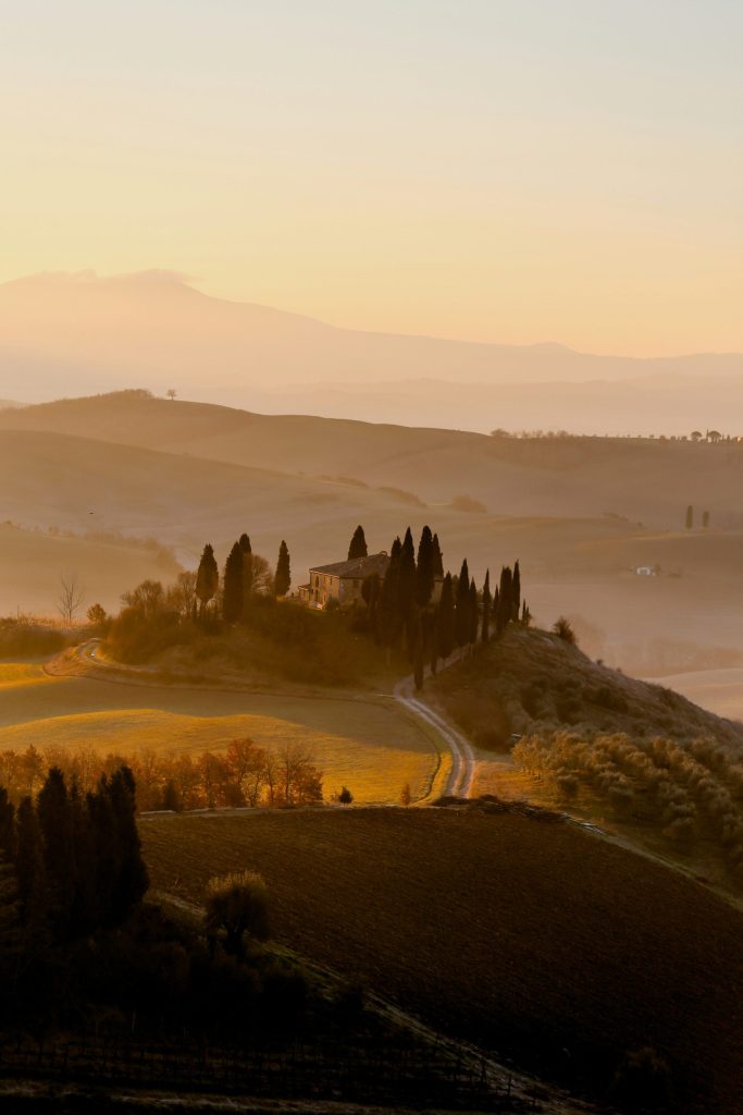 Paisaje primaveral de la Toscana con colinas verdes y caminos sinuosos.