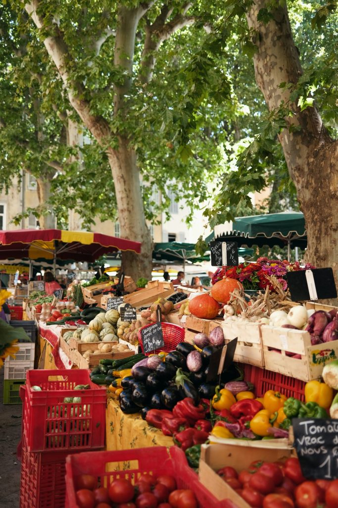 Mercado al aire libre en la Provenza con productos locales y flores.