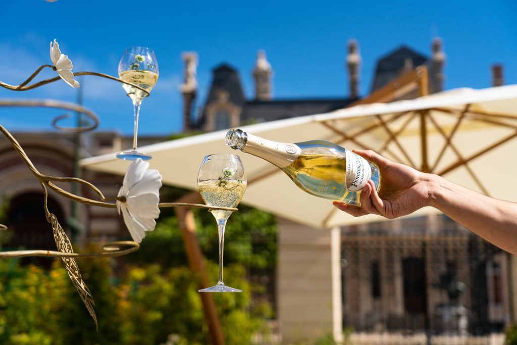 Servido de copa de champagne francés helado Perrier-Jouët en jardín de bodega