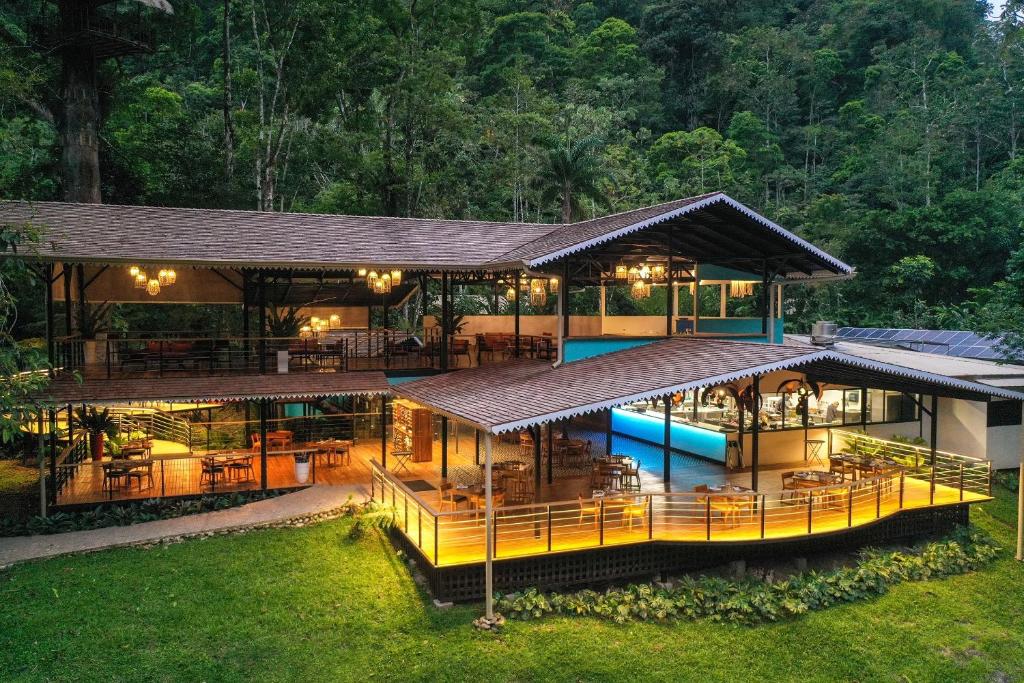 Hotel ecológico de madera de dos pisos con iluminación cálida en medio del bosque tropical de Costa Rica.