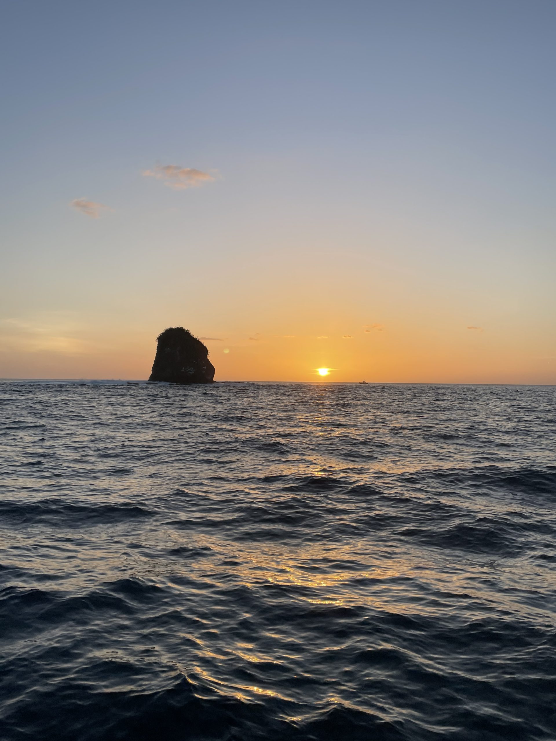 Atardecer sobre el mar en Costa Rica con un islote rocoso en el horizonte